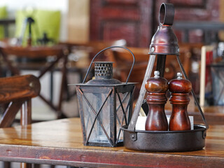 wooden salt and pepper shakers on old brown wooden table in a restaurant