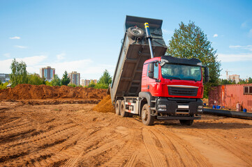 a dump truck unloads sand. construction of a new road