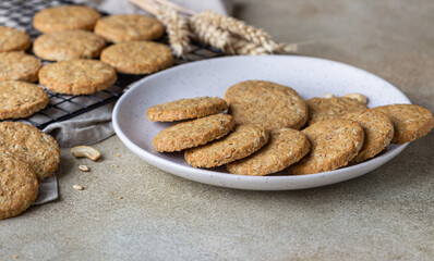 Oatmeal cookies with cereals, seeds and nuts, concrete background. Healthy vegan cookies.