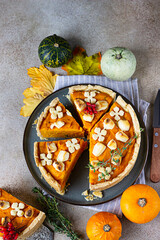 Top view of pumpkin tart or pie with feta cheese and thyme. Fall season concept. Cozy autumn food background.