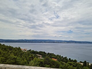Beautiful landscape with shoreline of Makarska Riviera and Adriatic Sea in Croatia on a cloudy summer day. Seaside view with fresh air from pine trees.