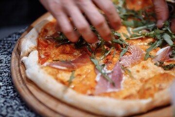 Cook in the kitchen putting the ingredients on the pizza. Pizza concept. Production and delivery of food