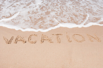 Fototapeta premium Vacation Inscription on a sandy sea coast
