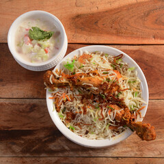 Traditional Hyderabadi Chicken dhum Biryani made of Basmati rice cooked with masala spices, served with raita, selective focus