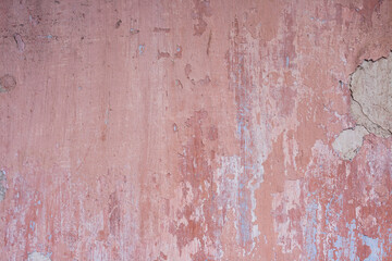Old distressed wall with pink peeling plaster