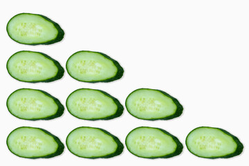 Nine cucumber circles are isolated on a white background and laid out in the form of a triangle.