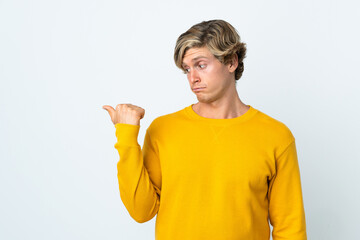 English man over isolated white background unhappy and pointing to the side