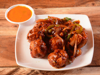 Veg schezwan momo with sauce served over a rustic wooden background, selective focus