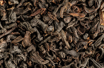 Brown flakes of black loose leaf tea - India variety. Dry leaves under 1.5x magnification microscope -  image width = 23mm