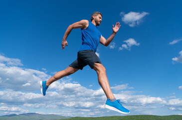 sportsman sprinter with muscular body running in sportswear outdoor on sky background, stamina.