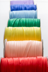 rolls with multi-colored ribbons for clothes on a white background