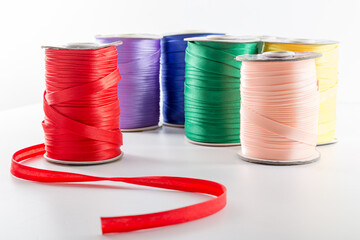 rolls with multi-colored ribbons for clothes on a white background