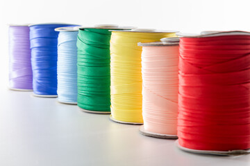 rolls with multi-colored ribbons for clothes on a white background