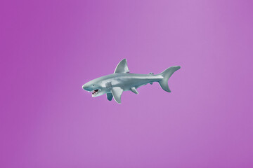 Naklejka premium Toothy shark toy on a pink background with free space.
