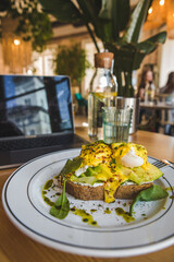 toast with avocado and eggs on the plate in restaurant