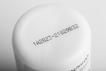 Lot number and manufacturing date on the bottom of the product with isolated white background.