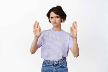 Young modern woman show block, stop no gesture, decline, rejecting something, raise palms and...