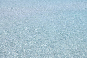 Fototapeta na wymiar Water ripple over sandy beach stock photo. Clear water reflections on shallow sandy beach bottom.
