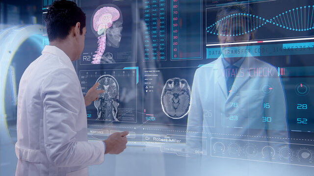 Two Doctors Using Large Video Conference Glass Screen With Futuristic Holograms To Analyze A Patient's Medical MRI Diagnosis. Concept Of: Medicine, Doctors, Future, Holography