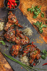 Baked chicken wings and legs with sesame seeds in honey mustard sauce with Indian spices. The concept of Indian cuisine.