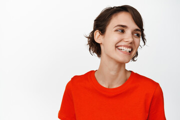 Close up portrait of carefree brunette girl laughing, smiling happy, looking aside, standing over white background