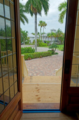 Looking out front door at street, palm trees and houses in tropical florida location