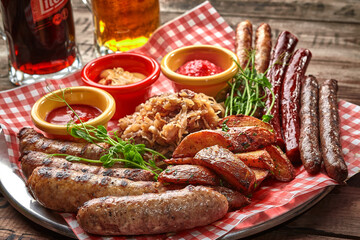 Beer set of grilled sausages with stewed cabbage, potato wedges and sauces
