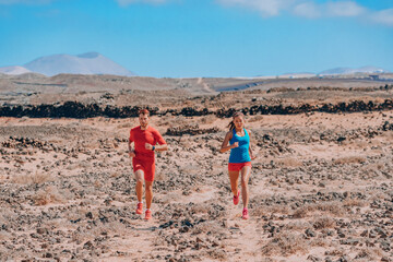 Sport athletes runners trail running training endurance in desert summer landscape. Man runner...