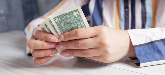 woman counting money in front of the table