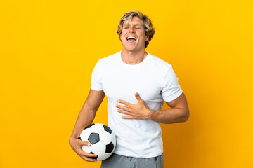 English football player over isolated yellow background smiling a lot