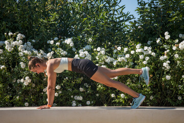 Young Caucasian slim athletic woman doing arm exercises. Fitness concept