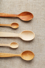 Wooden spoons made of natural wood on burlap fabric as a craft.