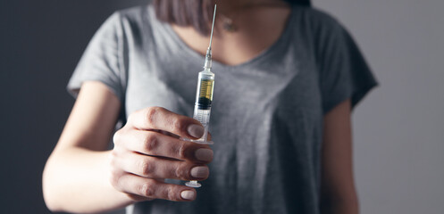 girl holding a syringe. addiction concept