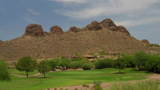 A high definition aerial view of a desert golf course located in the American southwest. - Powered by Adobe
