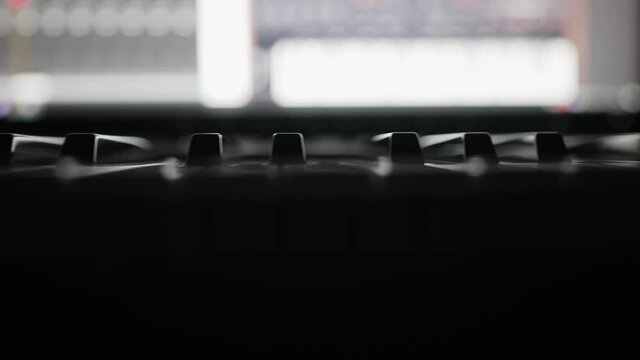 Musical keyboard keys in front of pc in recording studio.