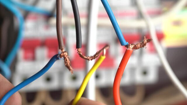 Male electrician connects electrical wires at home, close up. Very dangerous connection of electrical cables