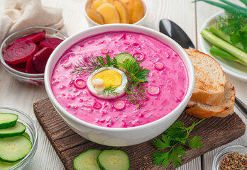 A plate of cold beetroot soup with egg and herbs on a light background. Close-up. - obrazy, fototapety, plakaty
