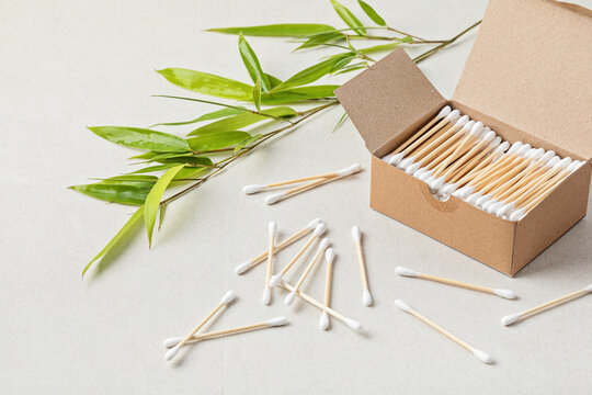 Bamboo cotton buds in carton box and bamboo branch. Ethical, sustainable no plastic lifestyle