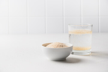 Psyllium husk and glass of water soluble fiber supplement for intestinal on a white background....