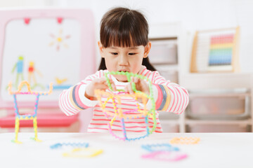 young girl playing creative 3d shape toy for homeschooling