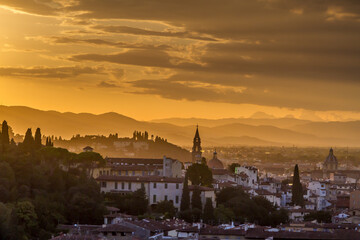 Fototapeta na wymiar The hills surrounding the beautiful city of Florence, Italy at sunset, with the trees and church towers silhouetted