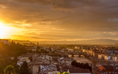 Fototapeta na wymiar The cityscape of beautiful Florence, Italy, as the cloudy sky erupts with color as the sun sets