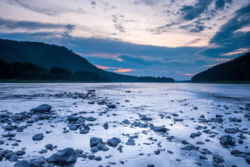 Landscapes of Siberia. Evening landscape at sunset. Mountains, forest, river and water at long exposure. Kemerovo region. Russia