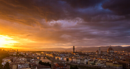 Fototapeta premium The cityscape of beautiful Florence, Italy, as the cloudy sky erupts with color as the sun sets
