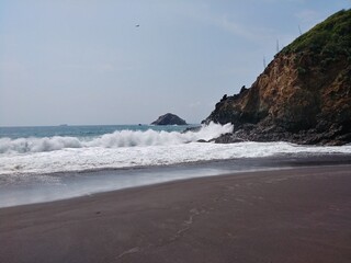 waves crashing on rocks beach coast water