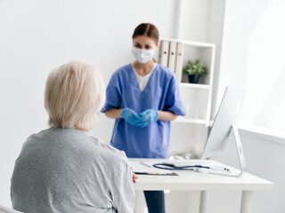 female doctor communicating with elderly patient in hospital safety infection covid passport