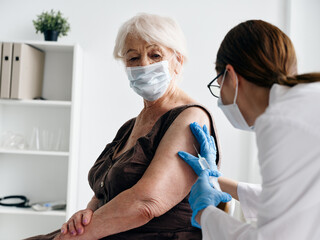 Nurse injects an elderly woman with vaccines passport coronavirus epidemic