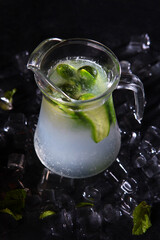 Homemade lemonade with cucumbers and mint. Refreshing drink. Lemonade in a glass jug. Vertical photo. Detox drink.