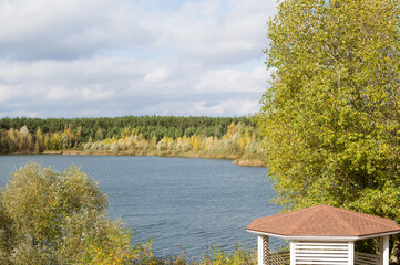 Autumn river forest landscape with pergola and yellow trees