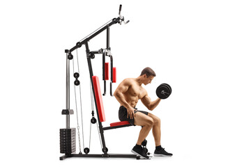 Shirtless musuclar man sitting on a fitness machine exercising with a dumbbell